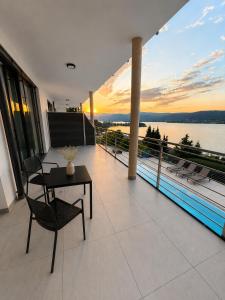 a balcony with a table and a view of the water at Maria Blick in Maria Wörth