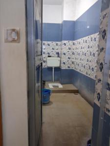 a bathroom with a toilet and blue and white tiles at Paras home in Deoghar