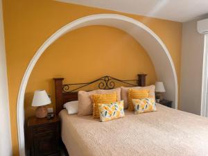 a large bed with an arch above it with pillows at Inari Guatemala in Guatemala
