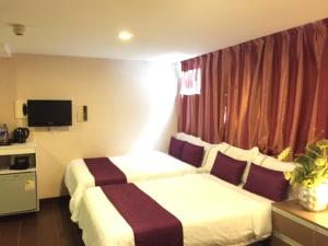 Habitación de hotel con 2 camas y TV en California Hotel, en Hong Kong