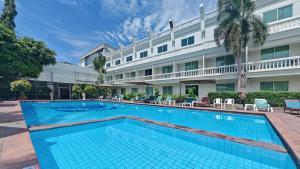 ein Schwimmbad vor einem Hotel in der Unterkunft Windmill Resort Hotel Pattaya in Pattaya North