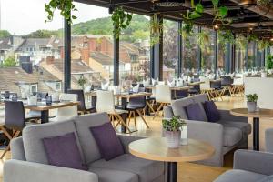 a restaurant with tables and chairs and large windows at INNSiDE by Meliá Aachen in Aachen