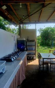a kitchen with a counter and a table and chairs at Veronica Palms in Pooc