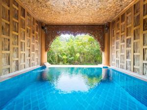 a swimming pool in a house with a window at Santhiya Koh Phangan Resort & Spa - Up to THB 2,000 Resort Credit per Night in Thong Nai Pan Noi +61 photos
