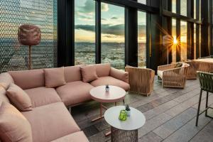a living room with a couch and tables and windows at Meliá Vienna in Vienna