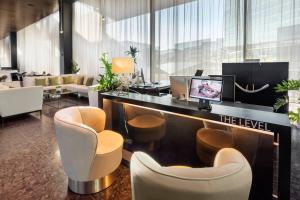 a hotel lobby with a reception desk and chairs at Meliá Vienna in Vienna +90 photos