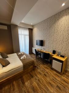 a bedroom with a bed and a desk and a tv at Seven Rooms Hotel in Tbilisi City