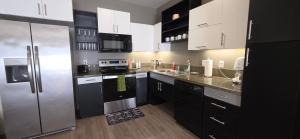 a kitchen with black cabinets and stainless steel appliances at 1-Bedroom Apartment near ALX Airport and the Ocean in Los Angeles