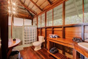 a wooden bathroom with a toilet and a sink at Villas Serenidad in Puerto Viejo +184 photos