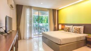 ein Hotelzimmer mit Bett und Fernseher in der Unterkunft Windmill Resort Hotel Pattaya in Pattaya North