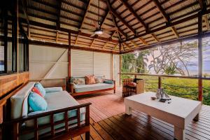 a screened in porch with a couch and a table at Villas Serenidad in Puerto Viejo