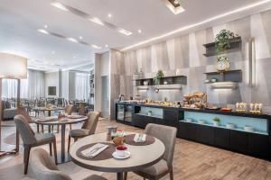 a restaurant with tables and chairs and a kitchen at Meliá Jardim Europa in São Paulo
