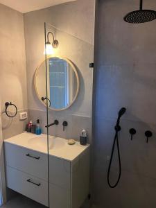 a bathroom with a shower and a sink with a mirror at חלום ליד הנחל in ‘Amir