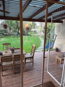 a wooden deck with a table and chairs on it at חלום ליד הנחל in ‘Amir +5 photos
