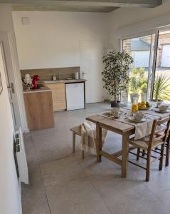 a kitchen and dining room with a wooden table at LE CHARME D OGNES in Ognes