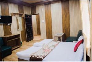 a hotel room with a bed and a tv and a room at Good Karma B&B in Khajurāho