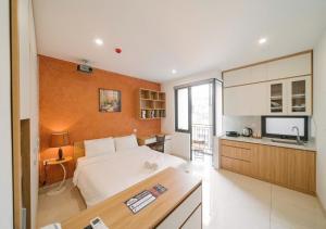 a bedroom with a large white bed and a kitchen at BOHO Homestay Hanoi - No81 Alley 8 Ton That Thiep in Hanoi