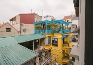 a yellow building with a blue balcony on top of it at BOHO Homestay Hanoi - No81 Alley 8 Ton That Thiep in Hanoi