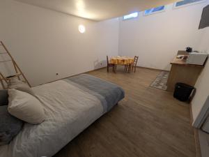 a bedroom with a bed and a table with chairs at LE CHARME D OGNES in Ognes