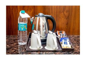 a tea kettle and a bottle of water on a counter at Good Karma B&B in Khajurāho +14 photos