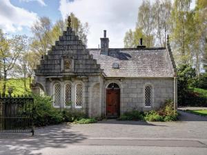 an old stone house with a wooden door at East Lodge - Crathes Castle in Banchory