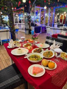 a red table with plates of food on it at Chevilly Resort & Camp in Bogor