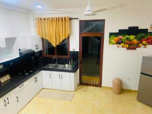 a kitchen with white cabinets and a sink at willow Blossoms in Pannipitiya