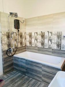 a bath tub in a bathroom with a shower at willow Blossoms in Pannipitiya