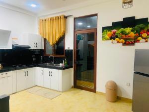 a kitchen with white cabinets and fruits and vegetables on the wall at willow Blossoms in Pannipitiya +7 photos