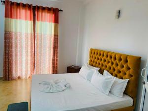 a bedroom with a bed with a yellow headboard at willow Blossoms in Pannipitiya