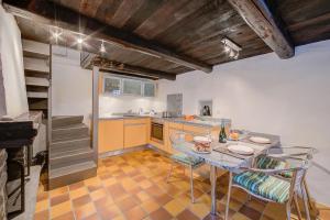 a kitchen with a table and chairs and a staircase at Rustico Caterina - Corippo- Happy Rentals in Corippo