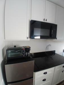 a kitchen with a microwave and a black counter top at Cozy Retreat 1 Bed and Bath in San Antonio