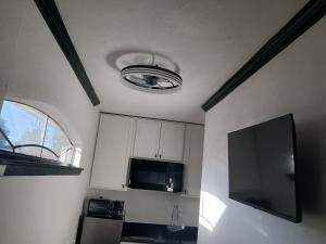 a kitchen with a ceiling with a television and a microwave at Cozy Retreat 1 Bed and Bath in San Antonio