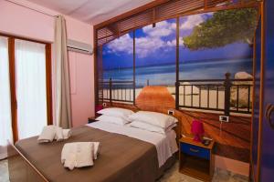 a bedroom with a large window with a view of the ocean at Hotel Roma in Pineto
