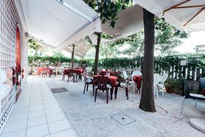 an outdoor patio with tables and chairs and umbrellas at Hotel Roma in Pineto