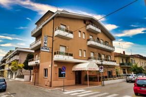 a tall building with cars parked in front of it at Hotel Roma in Pineto