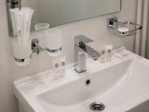 a white sink in a bathroom with a mirror at Urban Hotel in Bishkek