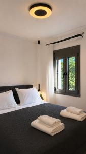 a bedroom with a bed with two towels on it at Elaia & Nyx Residence in Volos