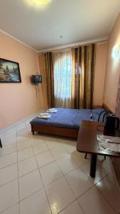a bedroom with a bed and a table in it at Стара Прага in Uzhhorod