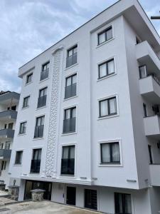 a white building with black windows at AiRPORT TO THE HOTEL AND HOME in Pelitli