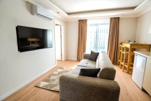 a living room with a couch and a tv on a wall at AiRPORT TO THE HOTEL AND HOME in Pelitli