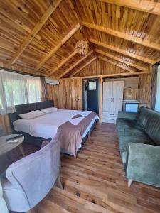 a bedroom with a bed and a couch in a room at Ruby Bungalow Alanya in Yaylalı