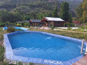 a large swimming pool in a yard with a house at Ruby Bungalow Alanya in Yaylalı