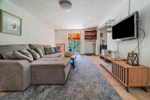 a living room with a couch and a flat screen tv at Family Retreat near Zagreb with Pool & Garden - Happy Rentals in Velika Buna
