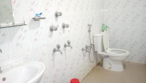 a bathroom with a toilet and a sink at Hotel Plaza in Bāndarban