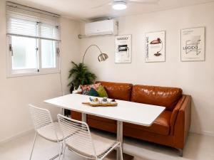 a living room with a white table and a leather couch at Woori Stay in Suwon