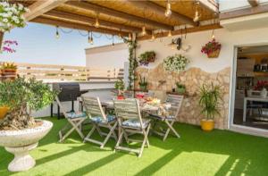 a patio with a table and chairs on the grass at Il Panoramico - Terrazza e Jacuzzi in Neviano