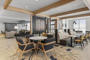 a lobby with tables and chairs and a restaurant at Hyatt House Thunder Bay in Thunder Bay