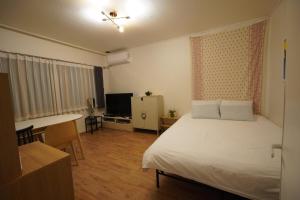 a bedroom with a bed and a desk and a television at Seoungho Kim in Ch'ŏngsap'o