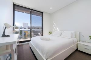 a bedroom with a white bed and a large window at Rouse Hills TownCentre luxury accommodation in Kellyville